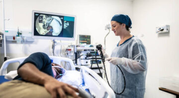 Doctor doing an endoscopy in the patient in the hospital room